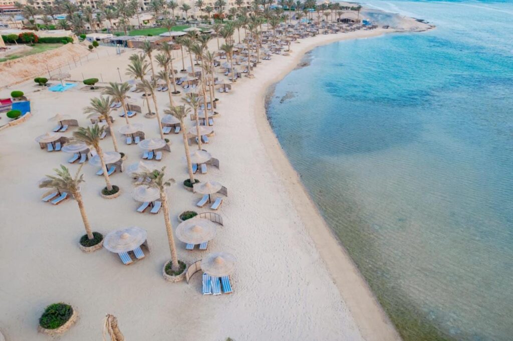Vista aérea de la playa del Blend Elphistone Resort, con sus palmeras, sus sombrillas de paja y el mar turquesa