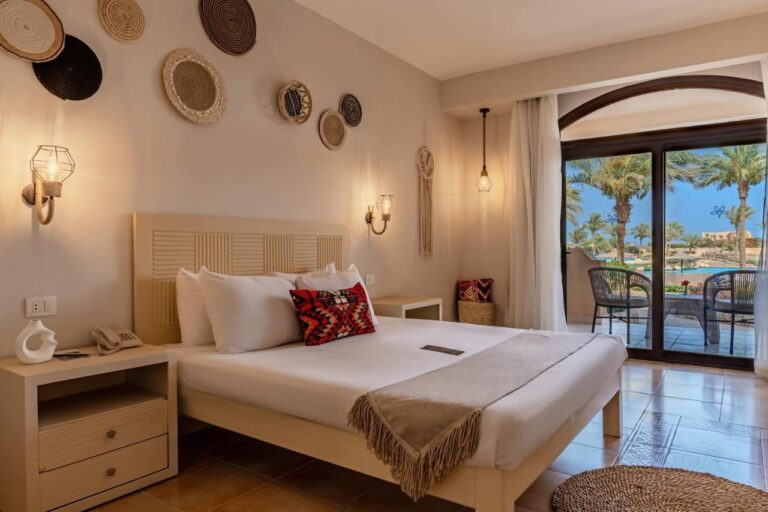 Una habitación con cama grande decorada con cestas trenzadas, abierta a una terraza y a la piscina