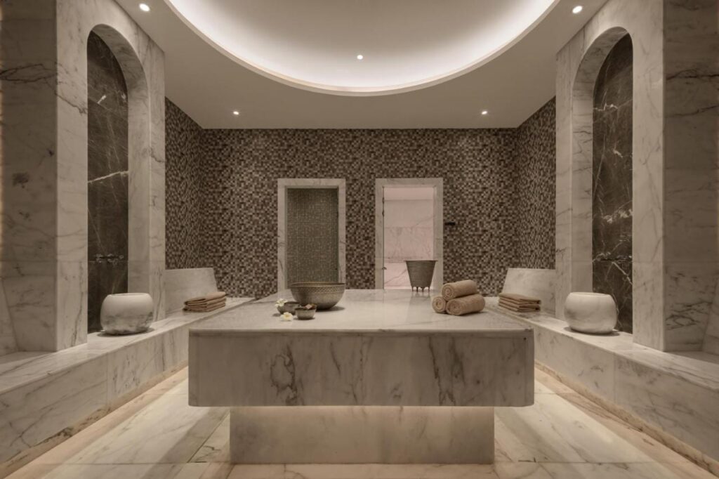 Una sala del spa del JAZ Elite Riviera revestida de mármol, con una gran mesa de piedra en el centro