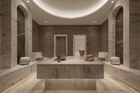 Una sala del spa del JAZ Elite Riviera revestida de mármol, con una gran mesa de piedra en el centro