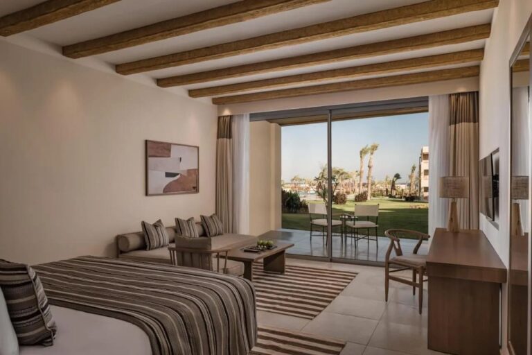Una habitación abierta a una terraza y al jardín, con zona de estar