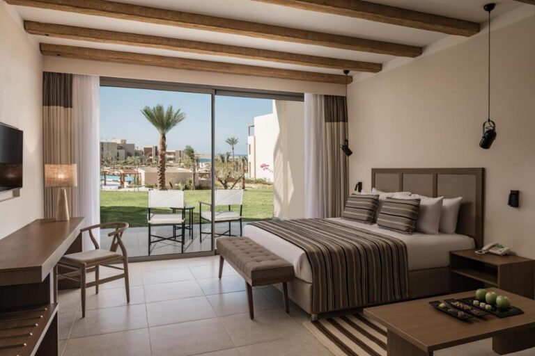 Una habitación con cama grande y acceso directo a la piscina, en el JAZ Elite Riviera