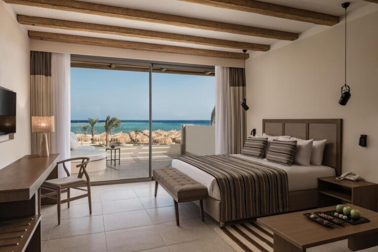 Una habitación con cama grande y un balcón frente al mar Rojo