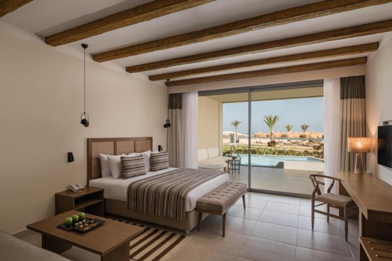 Una habitación con cama grande abierta a una piscina