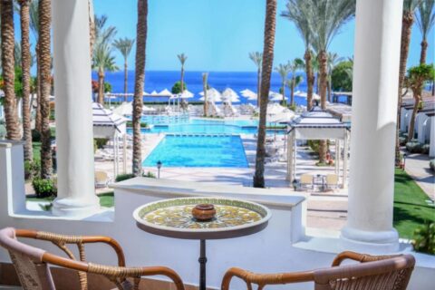 La vista desde una terraza del JAZ Fanara Resort sobre las piscinas, las palmeras y el mar Rojo