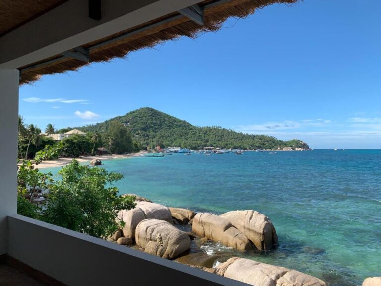 La bahía y sus rocas vistas desde una terraza cubierta del Koh Tao Heritage, con barcos fondeados