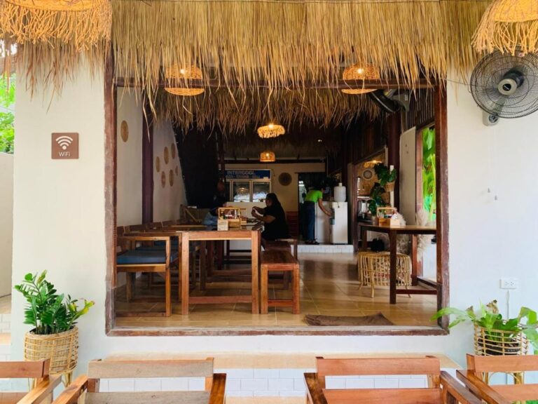 El comedor del restaurante, con sus mesas de madera y sus lámparas colgantes de ratán