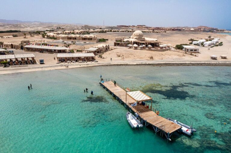 Vista aérea del Marsa Shagra Village, con su embarcadero, dos zódiacs y el complejo junto al agua turquesa