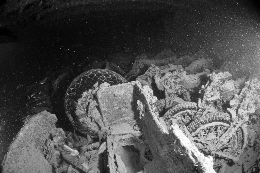 Motos apiladas en la bodega del Thistlegorm, foto en blanco y negro, con los neumáticos y las ruedas todavía visibles