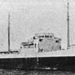 Foto de archivo en blanco y negro, granulosa, de un petrolero de perfil, con el puente en el centro, dos mástiles y la chimenea en la popa.