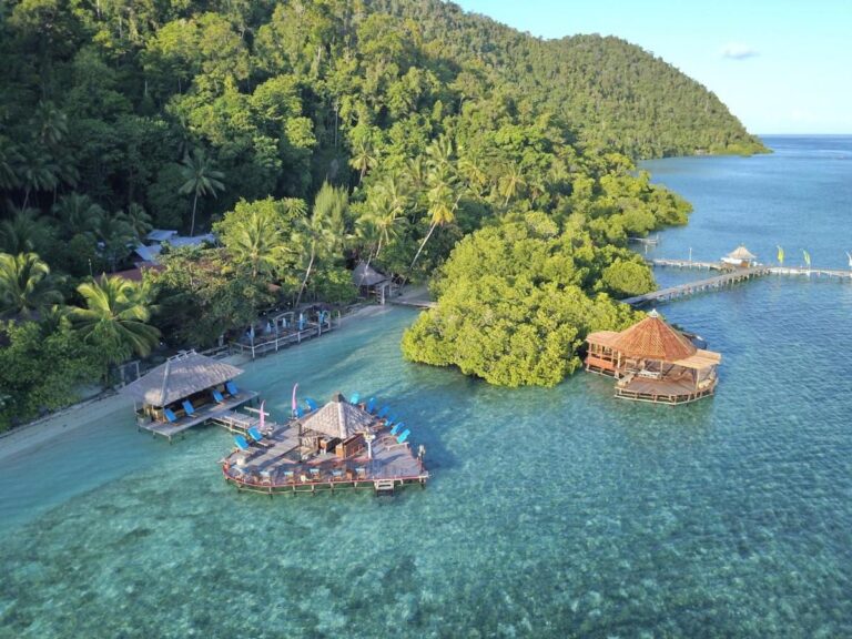 Las plataformas del Raja Ampat Dive Lodge al pie de una colina cubierta de bosque