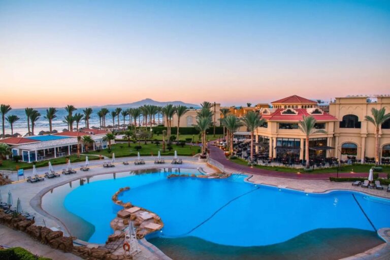 La gran piscina del Rixos Sharm El Sheikh al atardecer, frente a las palmeras y las montañas del Sinaí