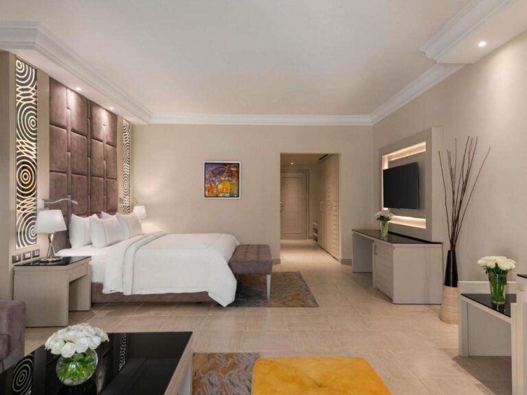 Una habitación con cama grande, una televisión en la pared y una zona de escritorio