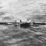 Foto de archivo en blanco y negro, tomada desde un avión, de un submarino que navega en superficie por un mar rizado, con la estela a lo largo del casco y la torreta en el centro.