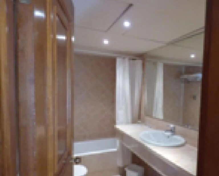 Un baño con bañera, cortina de ducha y una larga encimera