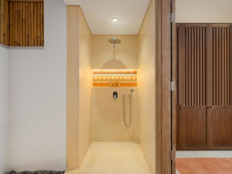 Una ducha a ras de suelo tras una puerta de madera