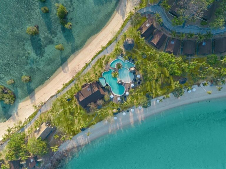 Vista desde el cielo de la piscina y los tejados del resort, entre dos playas de arena