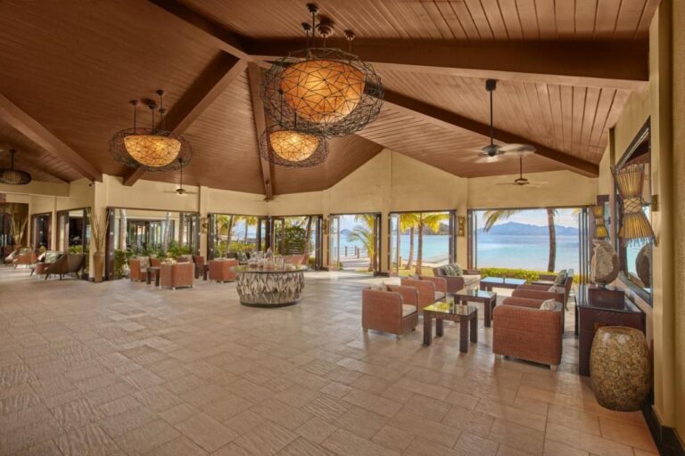 El vestíbulo del Two Seasons Coron, abierto a la playa, con sus sillones trenzados y sus grandes lámparas colgantes
