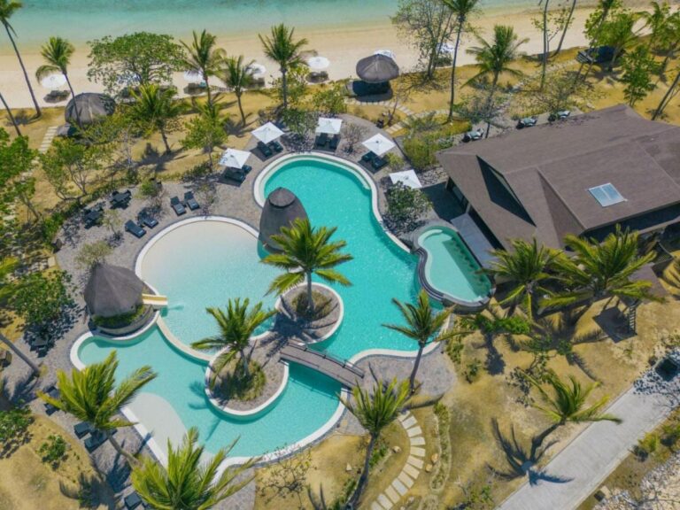 Vista desde el cielo de la piscina, de sus islotes con palmeras y de su pasarela